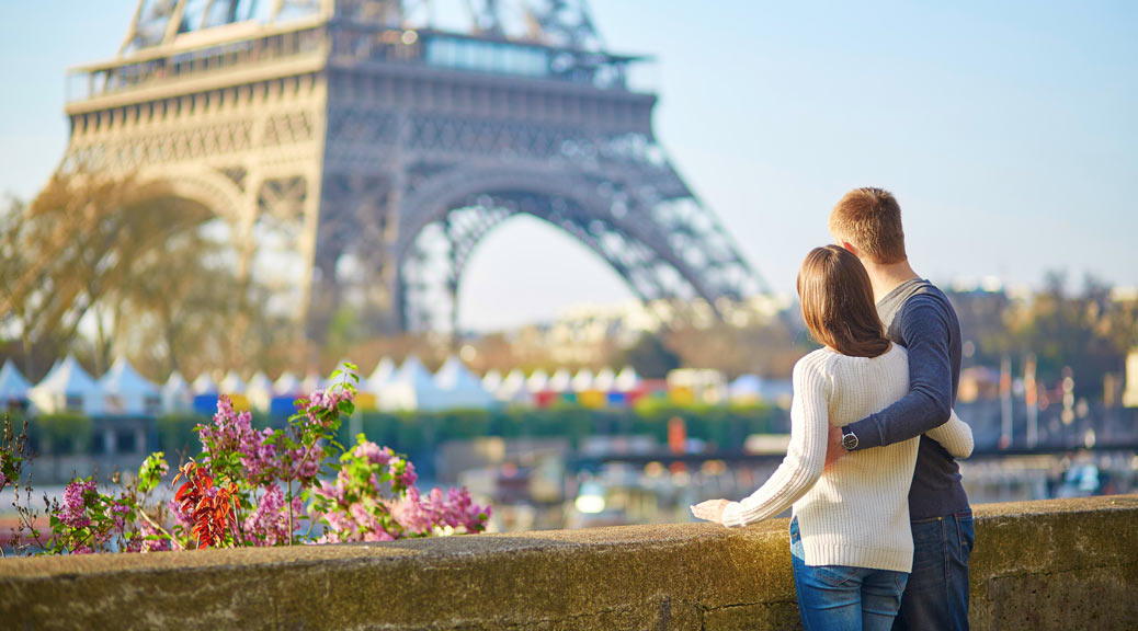 Young romantic couple in Paris having fun near the Eiffel tower.